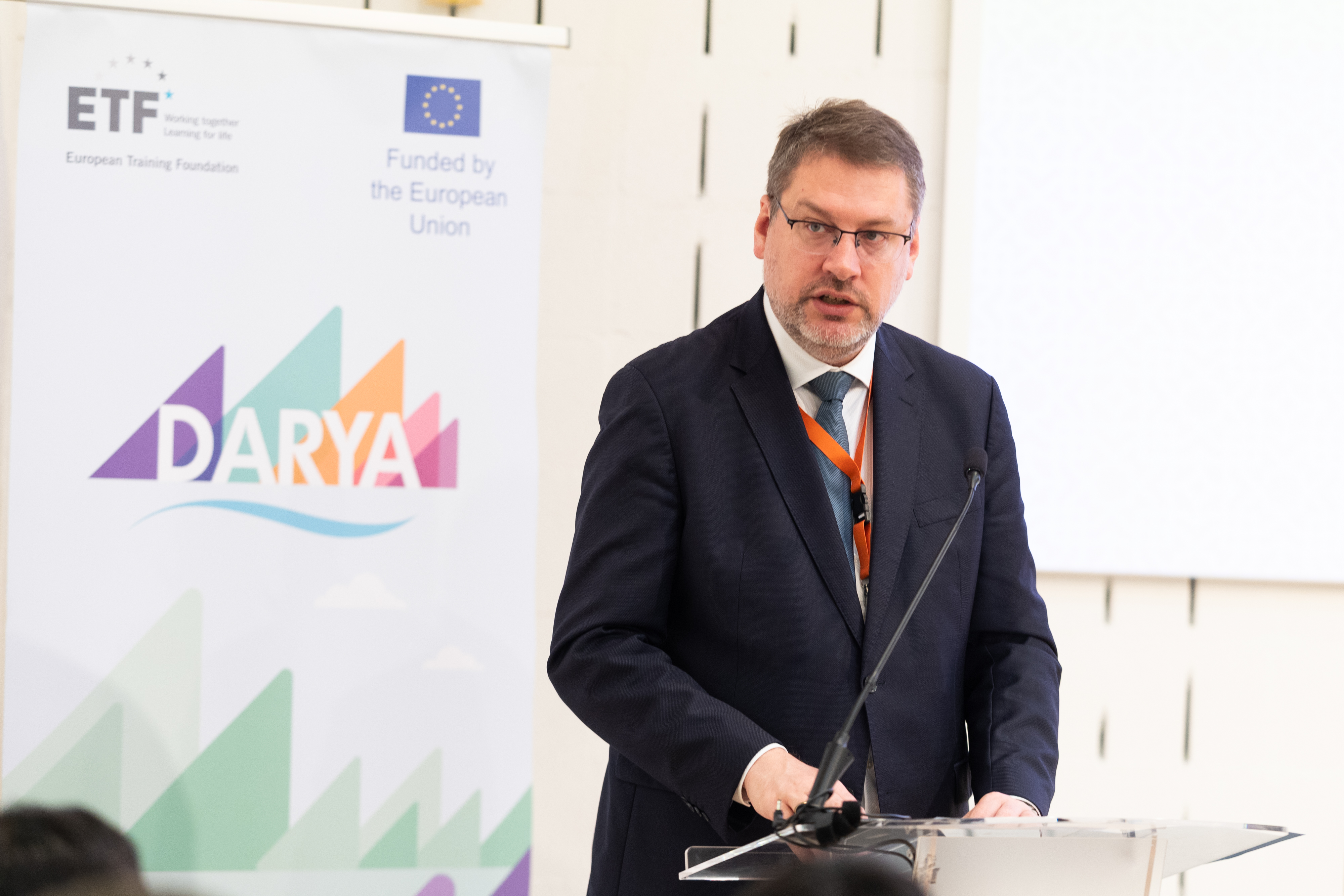 The EUSR speaking at a podium in front of the DARYA pull up banner