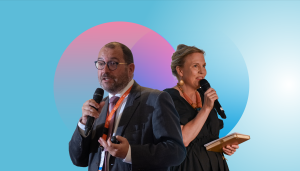 Dressed in dark grey, and viewed in semi-side-profile, against a bably blue background, with pink and blue circle graphic motifs, the outlines of EASNIE Director João Costa and ETF Director Pilvi Torsti are overlayed next to each other, facing in opposite directions, microphones in hand, as they address an audience of captive listeners