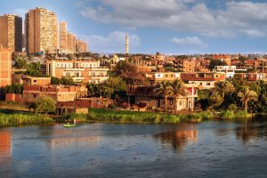 Landscape image of the skyline of the city Cairo, Egypt, displaying buildings and trees in the foreground with the sky in the background.