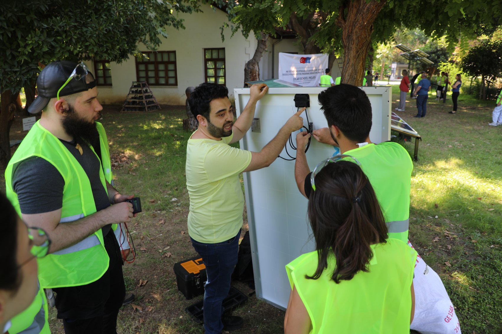A teacher with a group of students giving practical and technical training on solar panels