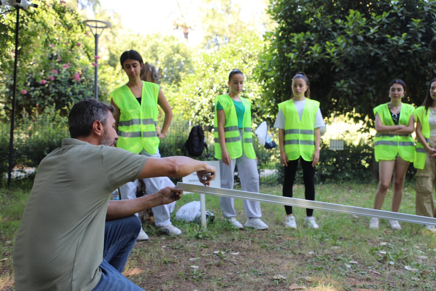 A teacher with a group of students giving a practical lesson on installing solar panels