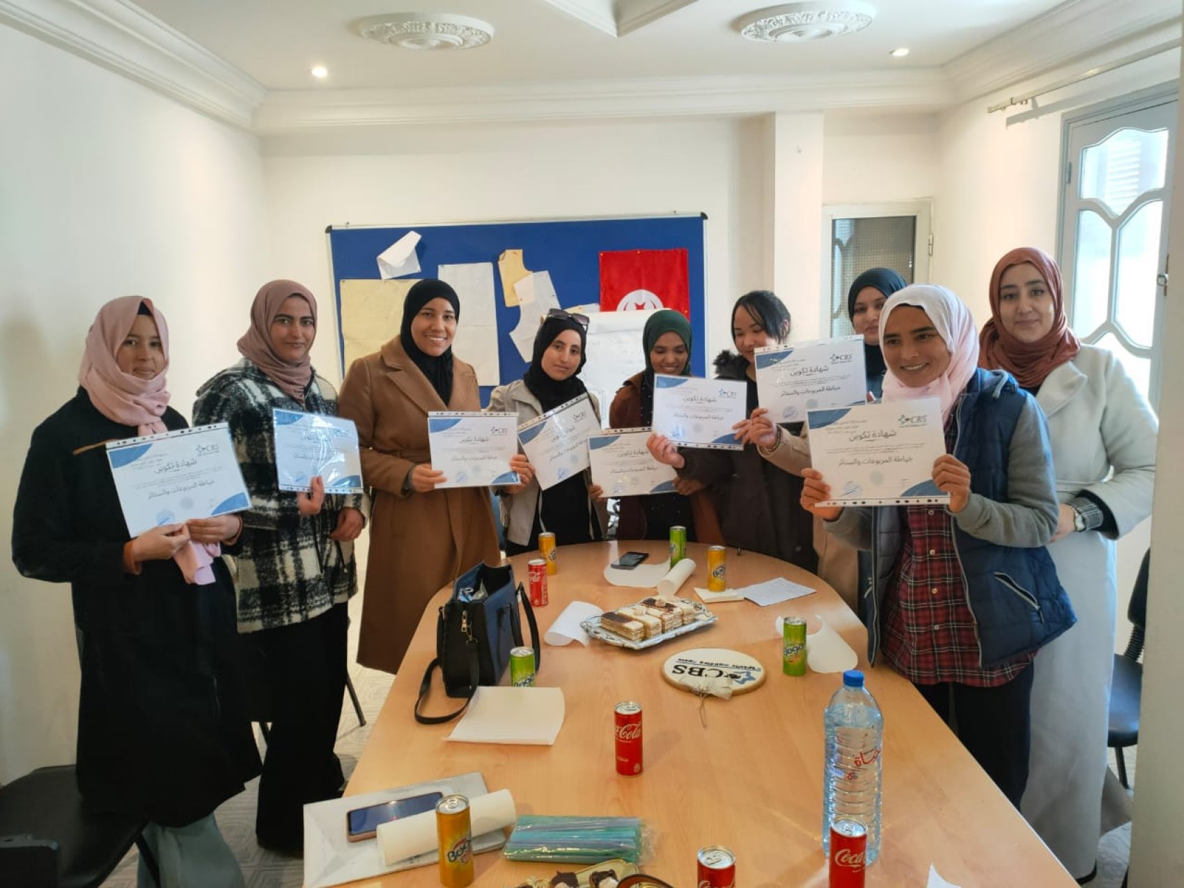 A group of women from rural Tunisia holding certificates recognising their success in completing a skills training and development course