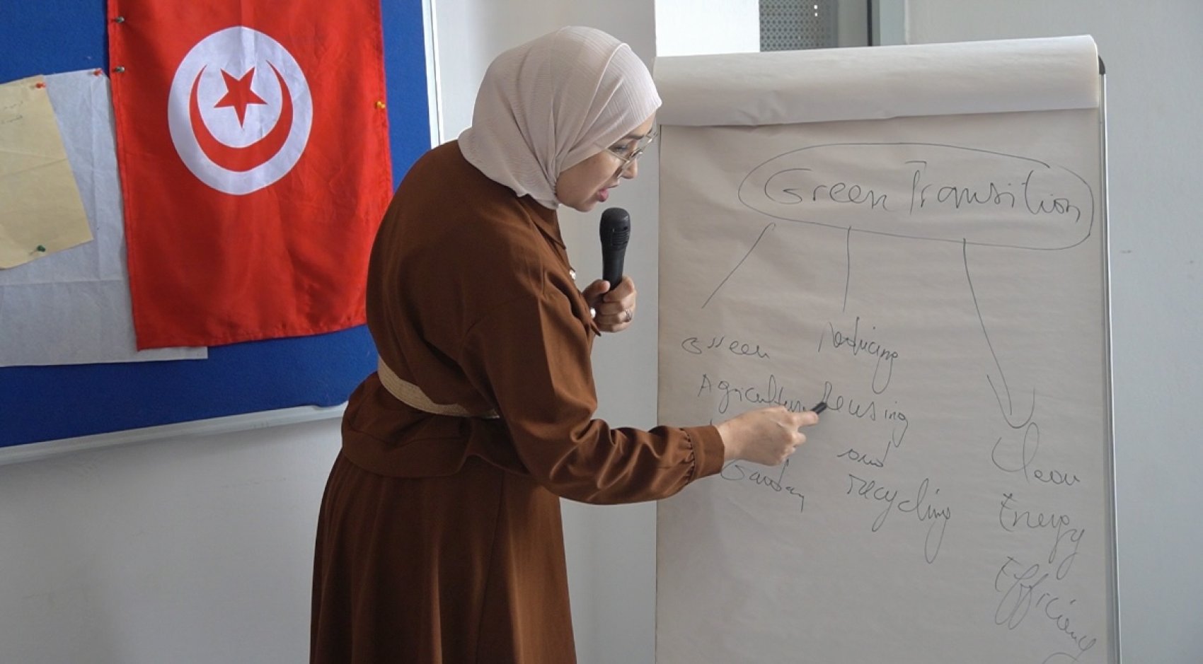 A trainer standing at a flip-chart delivering skills training on the green transition