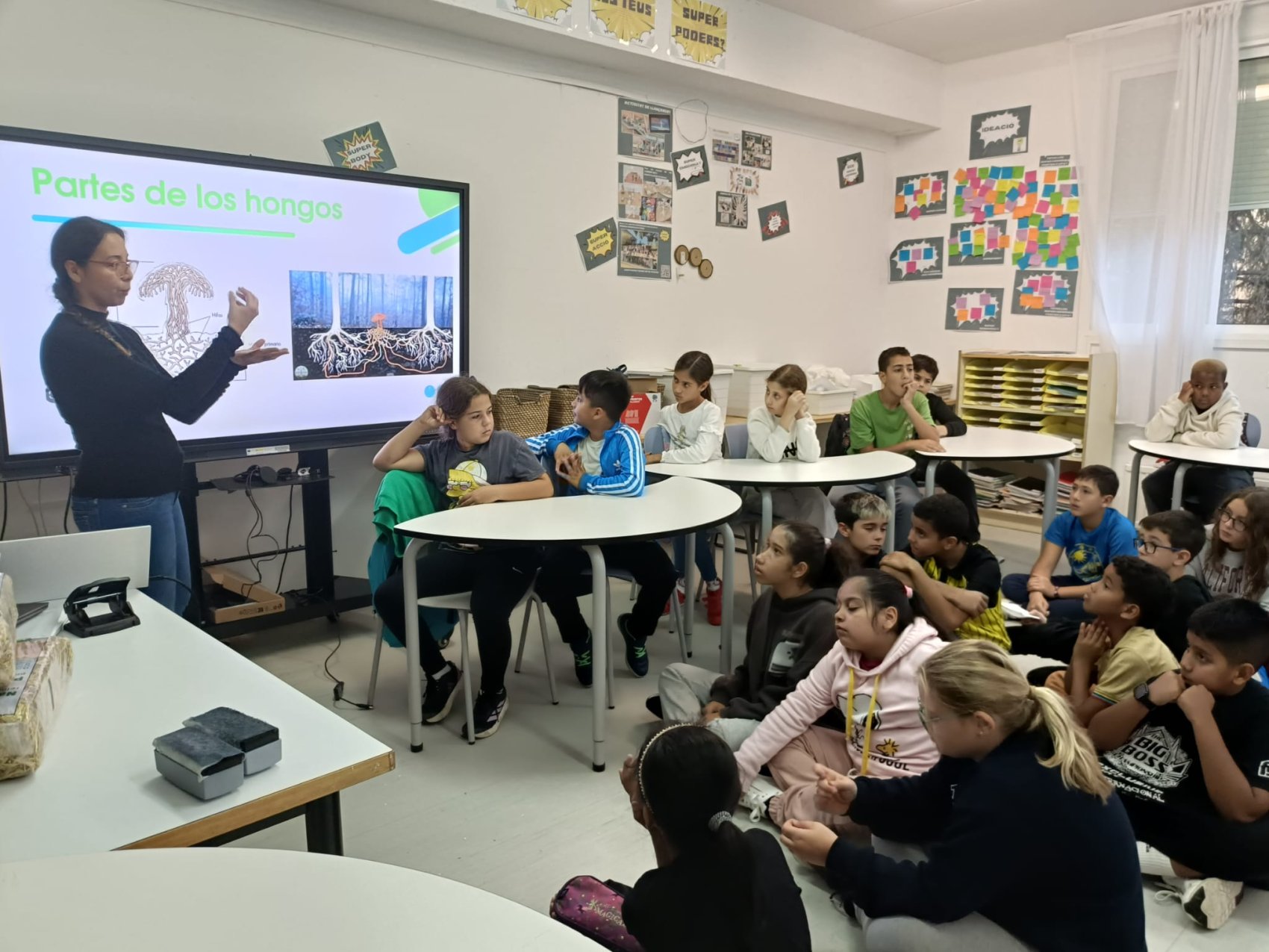 Children in a science class with a teacher using digital tools to help learning about climate and the evironment