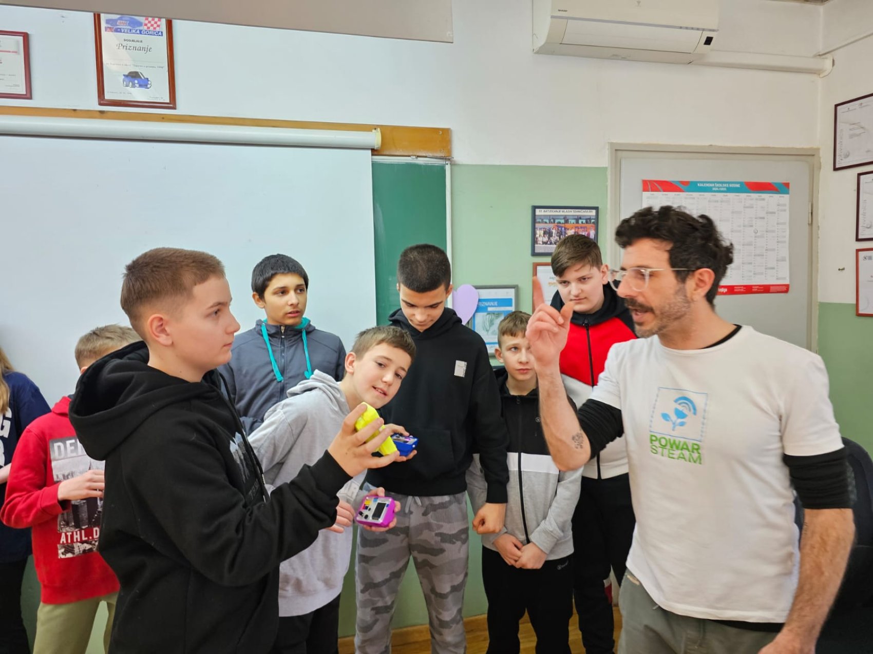 Teacher in class with students using the climate education digital tool, P-BIT Mini by Power STEAM