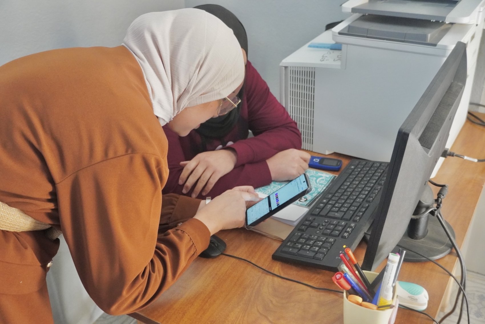 A trainer teaching digital skills to an adult learner in Tunisia