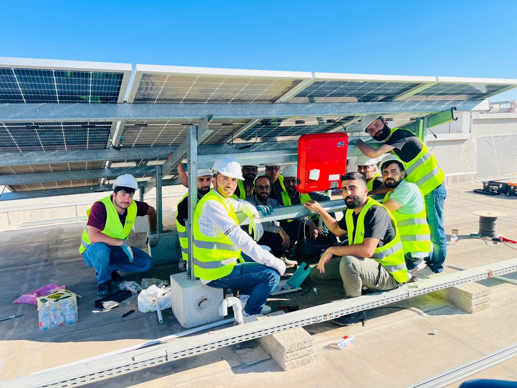 A group of trainees underneath a solar panel