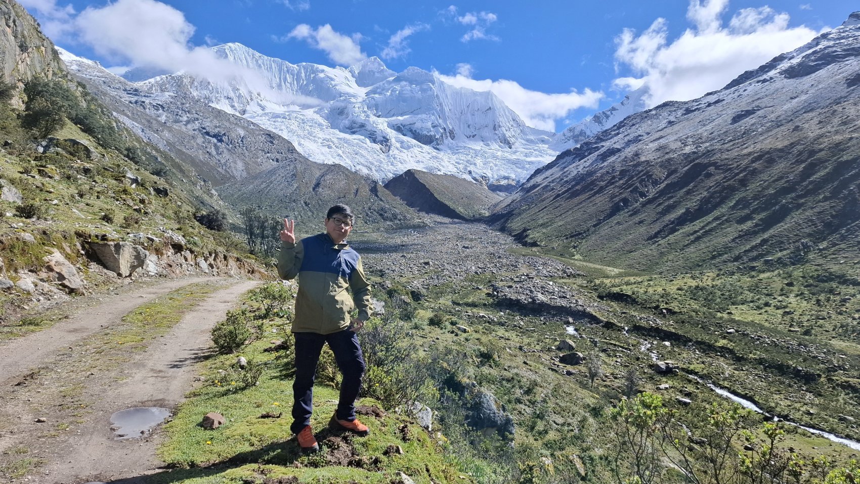 A young ambassador for glacier protection standing at the foot of a glacier in Peru