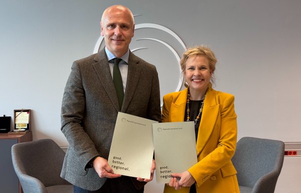 RCC Secretary General Amer Kapetanović (in grey) and ETF Director Pilvi Torsti (in yellow) stand side by side holding matching RCC publications