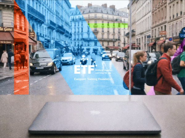 A Parisian streetscape is viewed head on, from the middle of a boulevard, with people, cars and restaurants visible, a colourful graphic overlay and the ETF logo in the middle