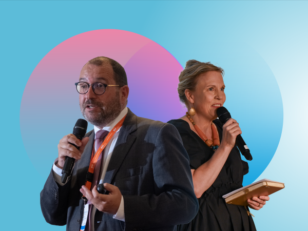 Dressed in dark grey, and viewed in semi-side-profile, against a bably blue background, with pink and blue circle graphic motifs, the outlines of EASNIE Director João Costa and ETF Director Pilvi Torsti are overlayed next to each other, facing in opposite directions, microphones in hand, as they address an audience of captive listeners