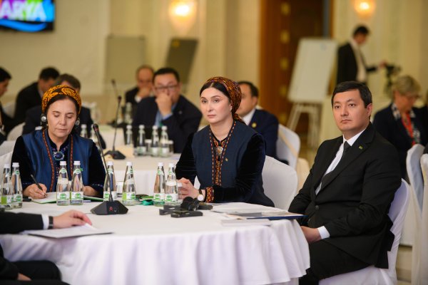 two women and one man sitting at a table, listening intently