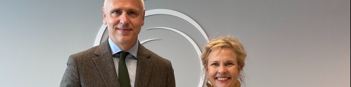 RCC Secretary General Amer Kapetanović (in grey) and ETF Director Pilvi Torsti (in yellow) stand side by side holding matching RCC publications